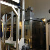 VEGA tunnelpesumasina väljalaadimise poolel asuv Smart Press RP 50_43 ja konveierlift pesutableti kuivatitesse viimiseks